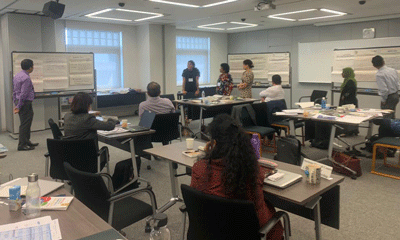 a group of people in a classroom with whiteboards