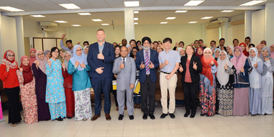 a group of people posing for a photo in a classroom