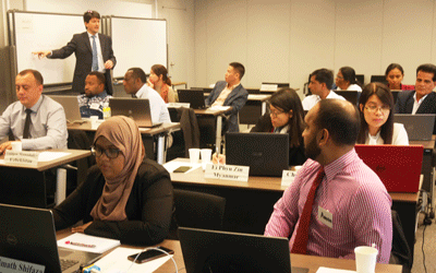 a group of people sitting at desks with laptops