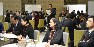 a group of people sitting at tables in a conference room