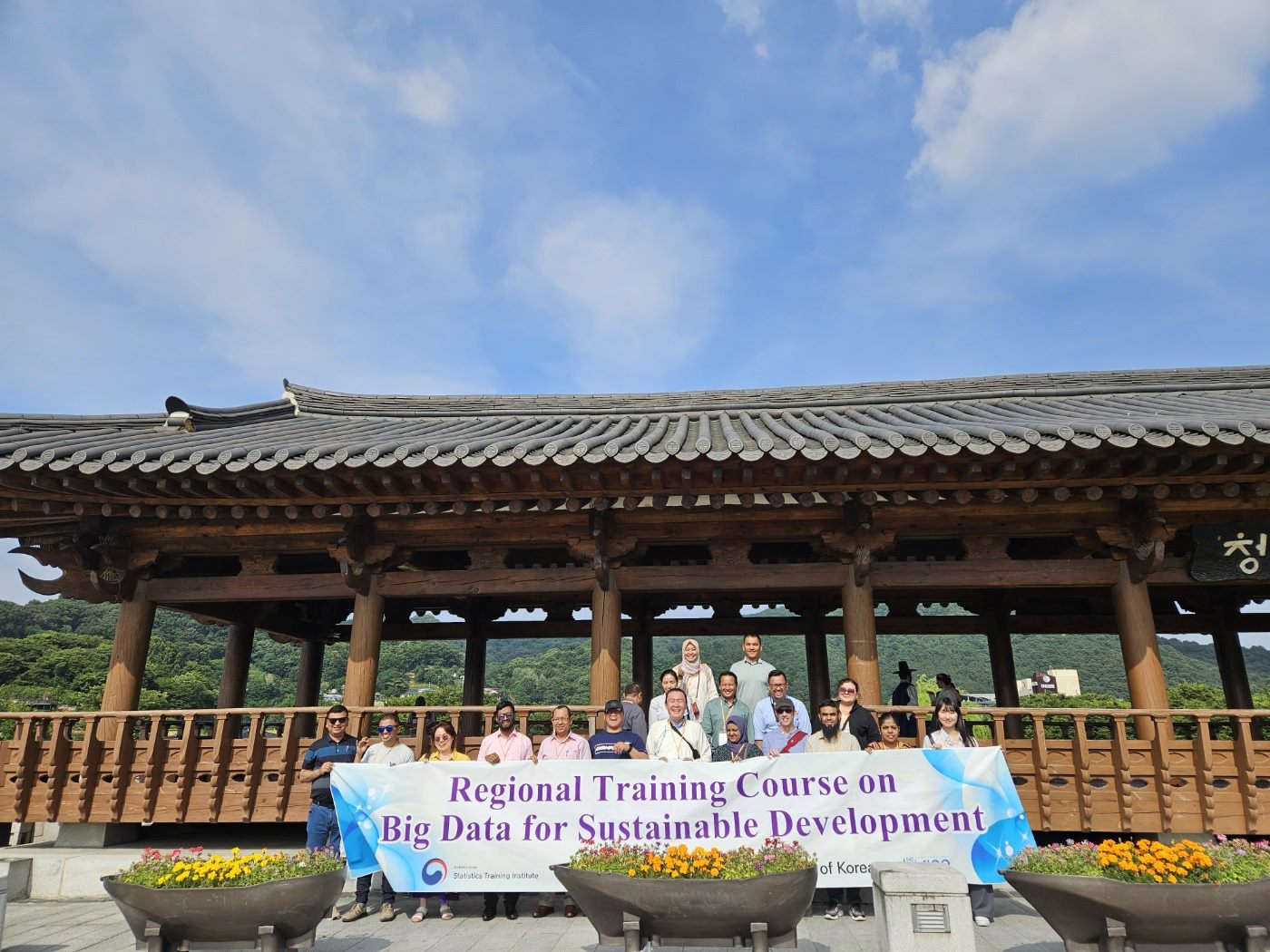 a group of people standing in front of a building with a banner